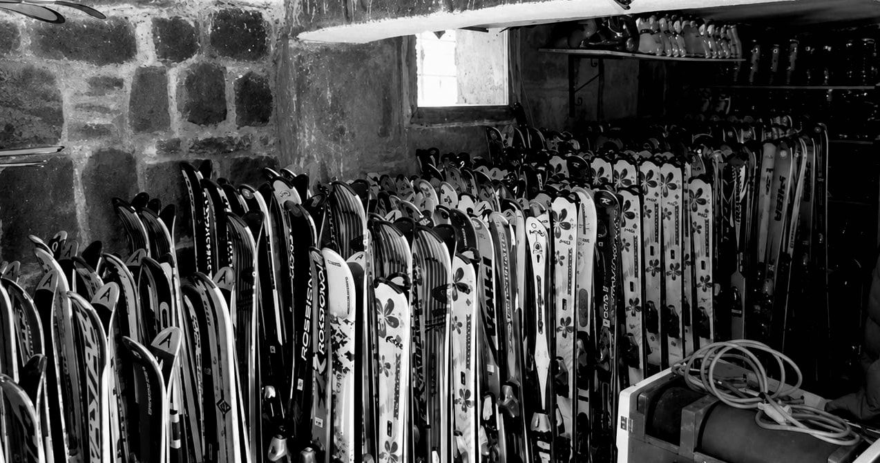 Rangée de skis alignés dans la réserve du magasin Univers Glisse