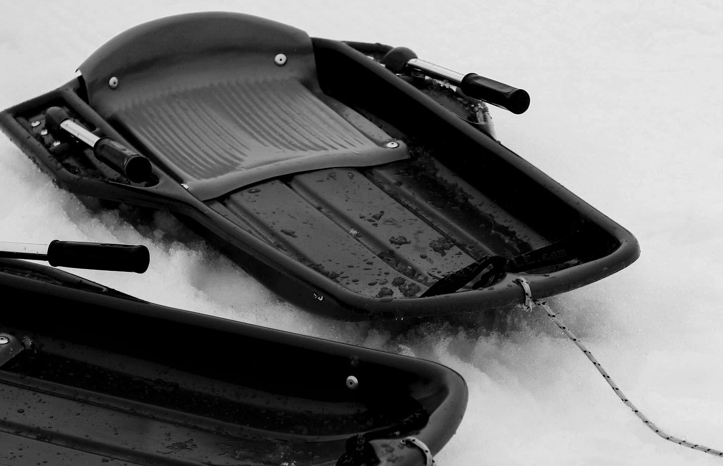 Deux luges rouges posées côte à côte dans la neige fraîche